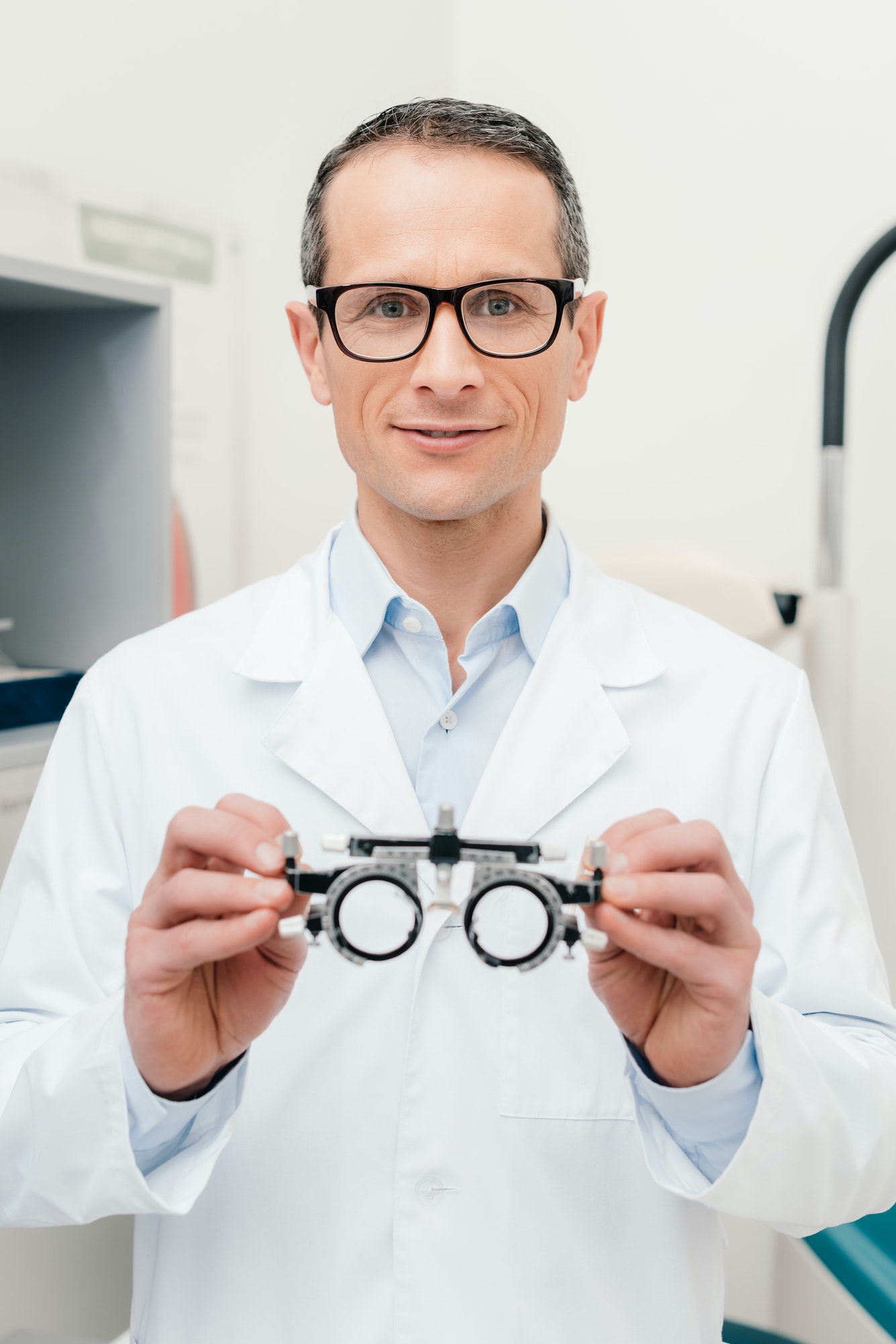 portrait-of-optometrist-in-white-coat-holding-trial-frame-in-hands-in-clinic.jpg